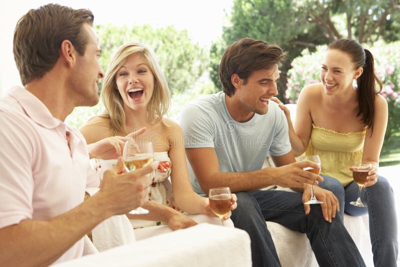 Group Of Young Friends Relaxing On Sofa Drinking Wine Together royalty free stock photo Group Of Young Friends Relaxing On Sofa Drinking Wine Together royalty free stock photo