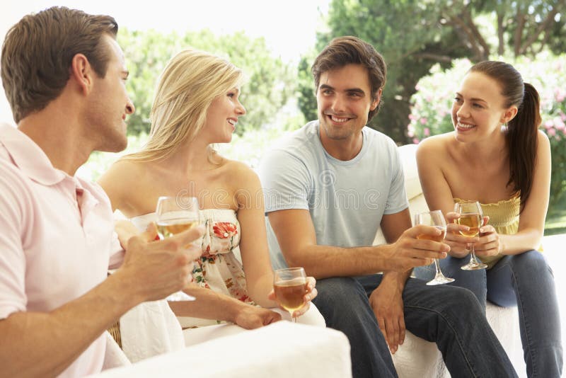 Group Of Young Friends Relaxing On Sofa Drinking Wine Together stock image Group Of Young Friends Relaxing On Sofa Drinking Wine Together stock image