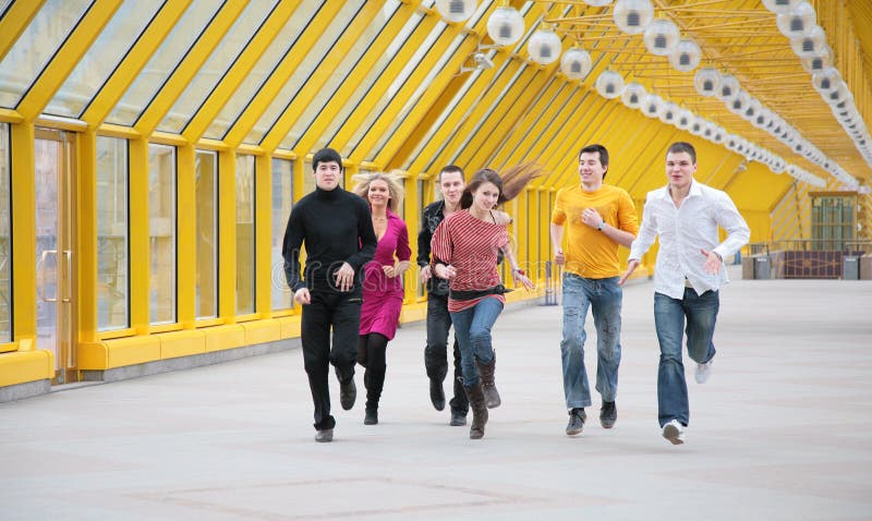Group of young friends runs on footbridge
