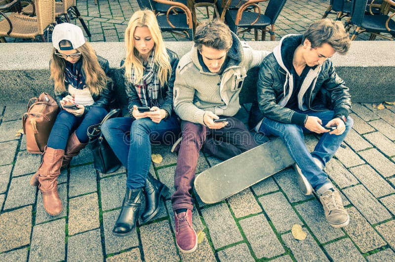 Gruppo di giovani hipster amici a giocare con smartphone con reciproco disinteresse verso ogni altro Moderno situazione di interazione tra tecnologia alienate stile di vita di connessione Internet wifi.