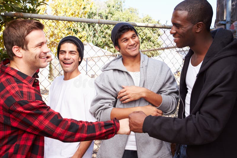 Group Of Young Men Greeting One Another In Urban S stock photo