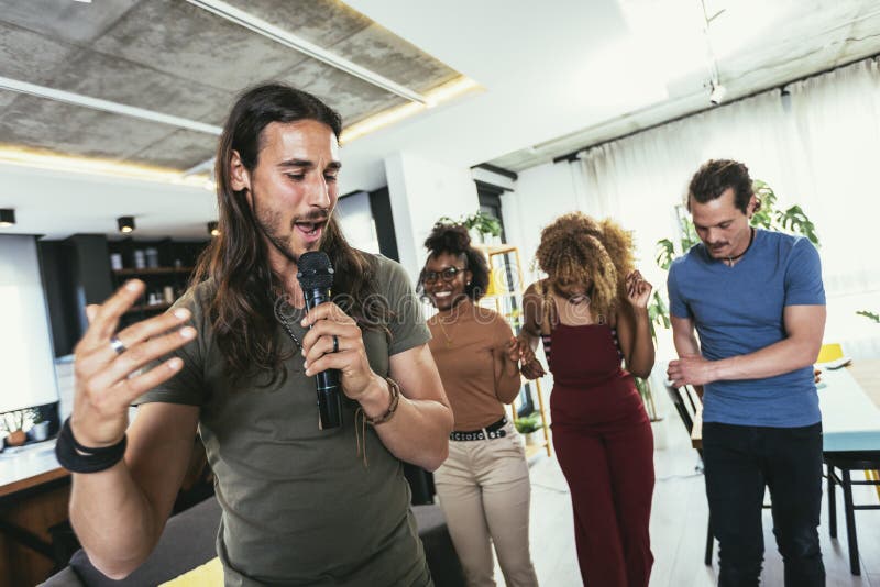 Young Multicultural Friends Having Party Singing Song Using Microphone