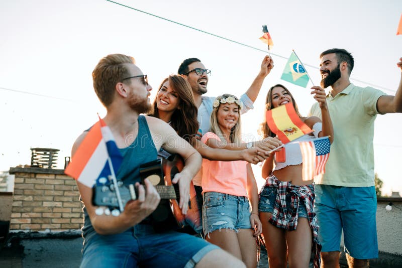 Group of young people having fun at a summertime party, at sunset stock photo Group of young people having fun at a summertime party, at sunset stock photo