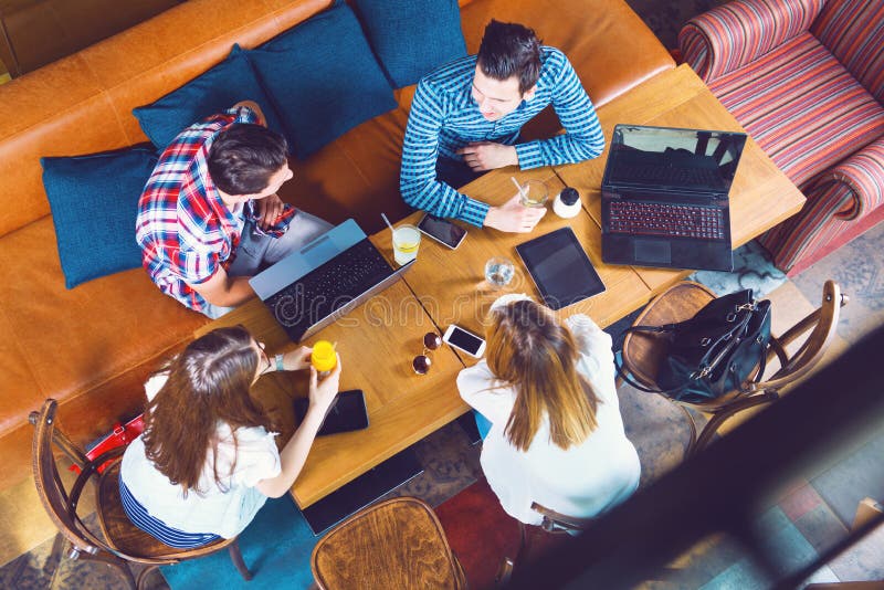 Group of young people sitting at a cafe, talking and enjoying stock image