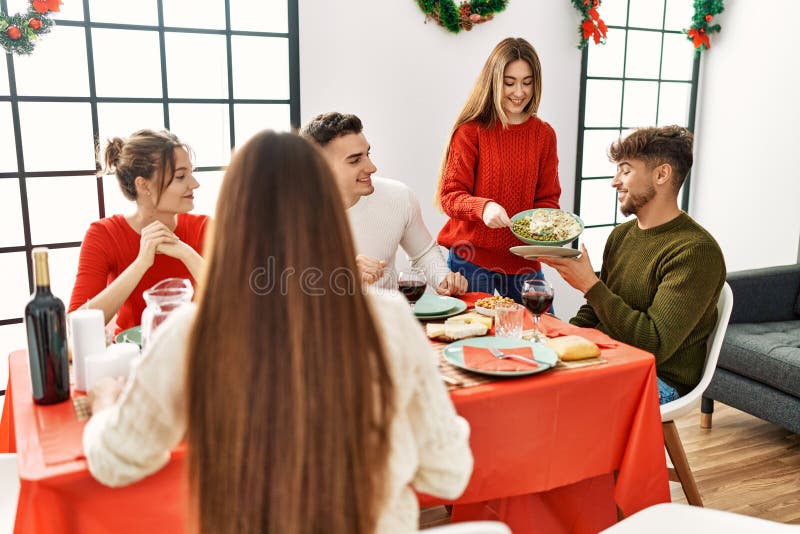 Group of Young People Smiling Happy Having Christmas Dinner at Home