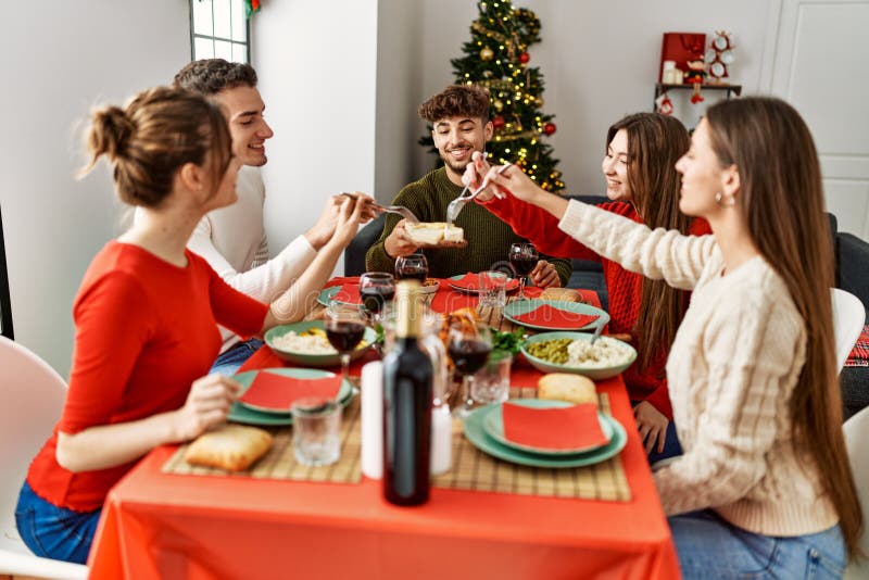 Group of Young People Smiling Happy Having Christmas Dinner at Home