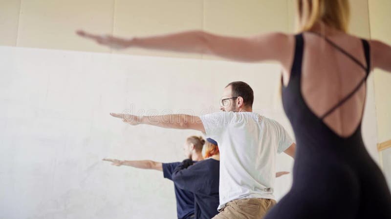 Group of young sporty people practicing yoga yoga class. attractive blonde woman on foreground.