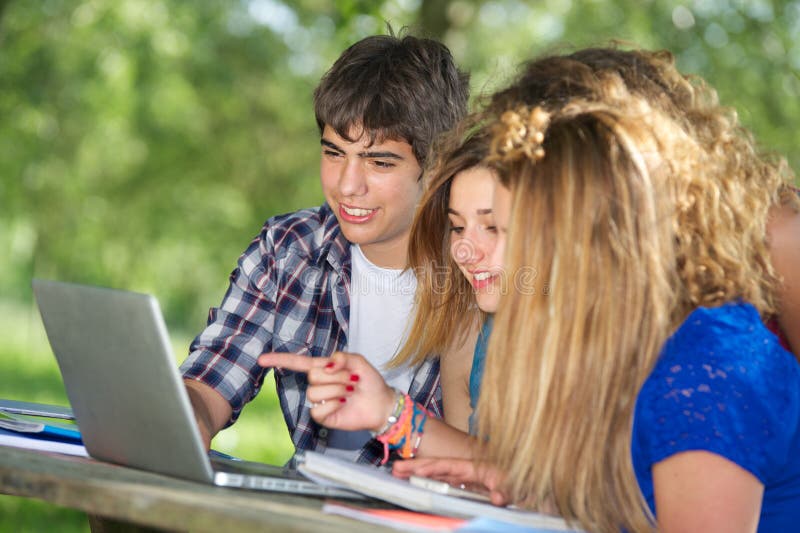 Group of young student using laptop outdoor