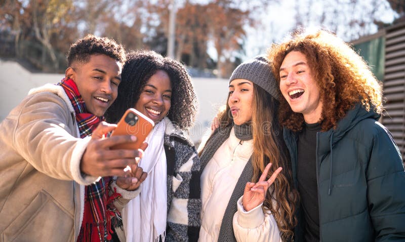 Group of young students taking a selfie outdoors in winter stock image