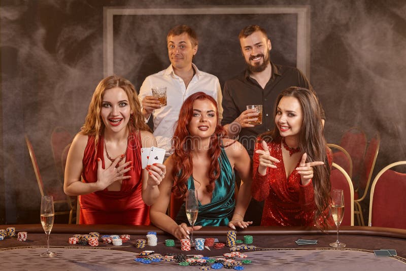 Group of a young wealthy friends are playing poker at a casino. royalty free stock photography Group of a young wealthy friends are playing poker at a casino. royalty free stock photography