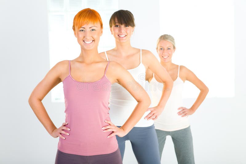 Three beautiful women dressed sportswear standing and looking at camera. Front view. Three beautiful women dressed sportswear standing and looking at camera. Front view.