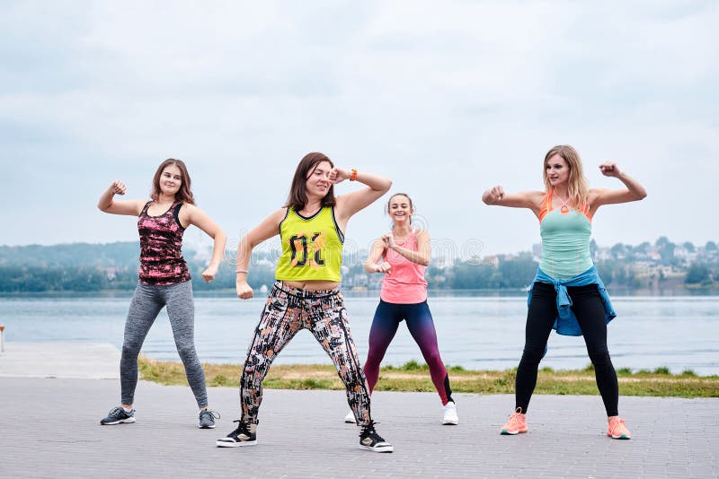 A Group of Young Women, Wearing Colorful Sports Outfits, Doing Zumba  Exercises Outside by City Lake. Dancing Training To Loose Stock Photo -  Image of sport, aerobic: 184326032