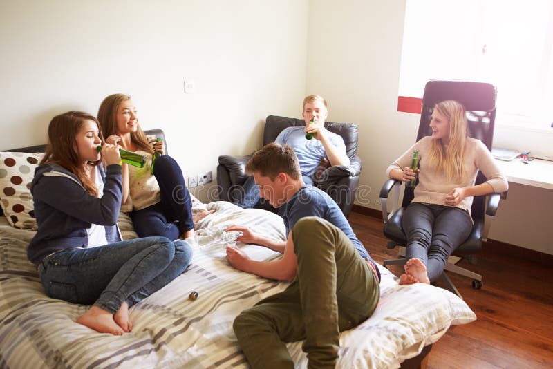 Groupe d'adolescents buvant l'alcool dans la chambre à coucher photo libre de droits Groupe d'adolescents buvant l'alcool dans la chambre à coucher photo libre de droits