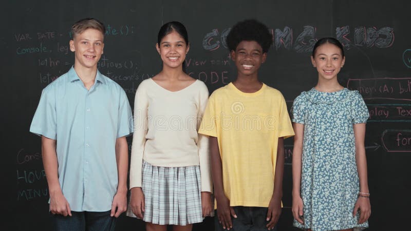 Groupe d'adolescents multiculturels regardant la caméra au tableau noir. édification banque de vidéos