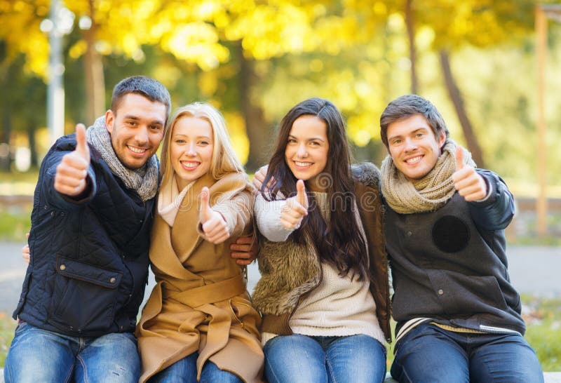 Groupe d'amis ayant l'amusement dans le parc d'automne photo libre de droits Groupe d'amis ayant l'amusement dans le parc d'automne photo libre de droits
