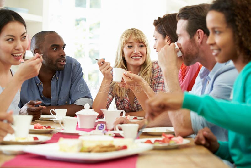 Group Of Friends Having Cheese And Coffee At Dinner Party Sitting Down Chatting To Each Other. Group Of Friends Having Cheese And Coffee At Dinner Party Sitting Down Chatting To Each Other