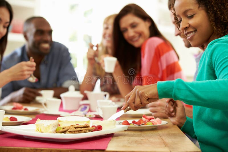 Group Of Friends Having Cheese And Coffee At Dinner Party Wife Woman Using Knife To Cut Cheese. Group Of Friends Having Cheese And Coffee At Dinner Party Wife Woman Using Knife To Cut Cheese