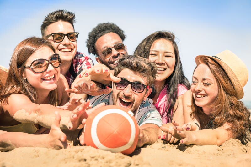 Groupe d'amis heureux multiraciaux ayant l'amusement aux jeux de plage photographie stock Groupe d'amis heureux multiraciaux ayant l'amusement aux jeux de plage photographie stock