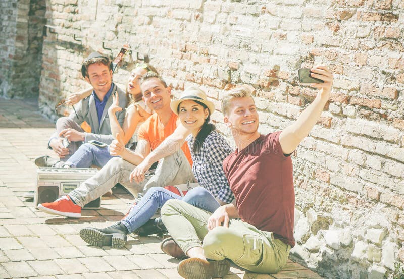 Groupe d'amis multiraciaux prenant un selfie avec une caméra mobile de smartphone - autoportrait des personnes heureuses photographie stock Groupe d'amis multiraciaux prenant un selfie avec une caméra mobile de smartphone - autoportrait des personnes heureuses photographie stock