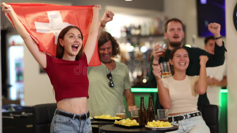 Groupe d'amis qui applaudissent l'équipe suisse dans un bar à bière banque de vidéos