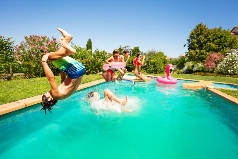 Groupe d'années de l'adolescence heureuses ayant l'amusement dans la piscine images stock Groupe d'années de l'adolescence heureuses ayant l'amusement dans la piscine images stock