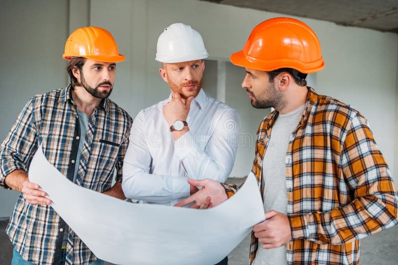 Groupe d'architectes beaux avec le modèle ayant la conversation à l'intérieur de images stock