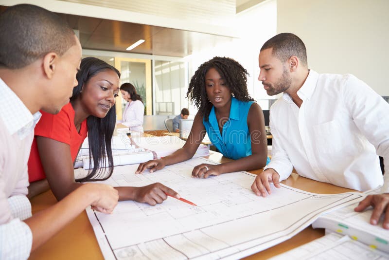 Group Of Architects Discussing Plans In Modern Office Pointing. Group Of Architects Discussing Plans In Modern Office Pointing