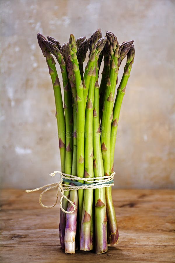 Groupe d'asperge verte fraîche se tenant sur une table en bois rustique photo libre de droits Groupe d'asperge verte fraîche se tenant sur une table en bois rustique photo libre de droits
