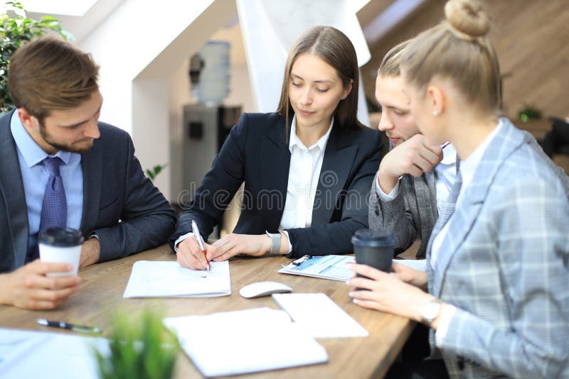 Groupe d'associ?s discutant des strat?gies lors de la r?union dans le bureau image stock Groupe d'associ?s discutant des strat?gies lors de la r?union dans le bureau image stock