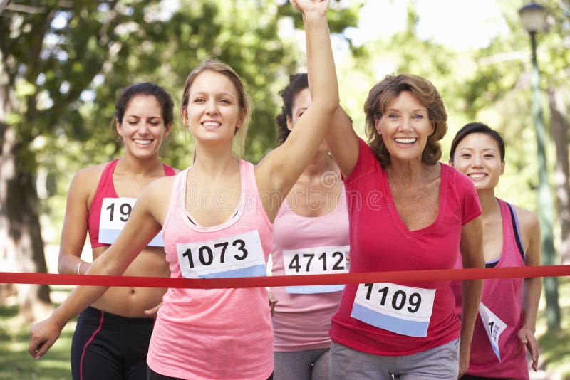 Groupe d'athlètes féminins accomplissant la course de marathon de charité