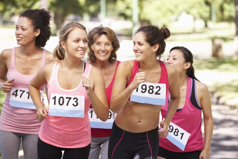 Groupe d'athlètes féminins concurrençant dans la course de marathon de charité photo libre de droits