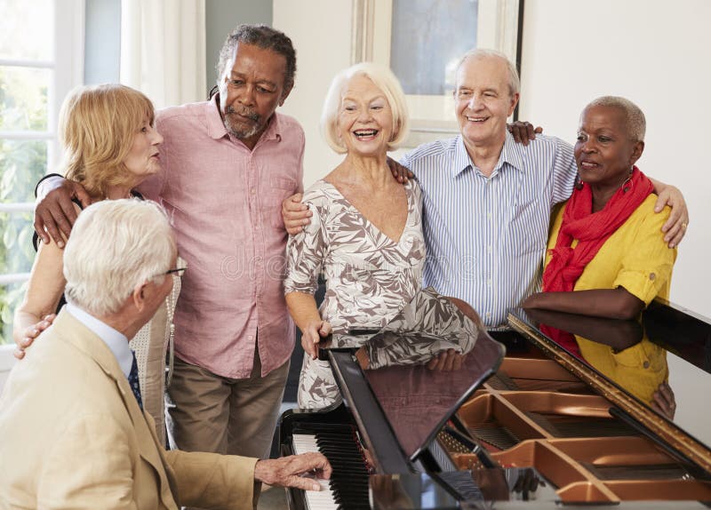 Group Of Seniors Standing By Piano And Singing Together. Group Of Seniors Standing By Piano And Singing Together