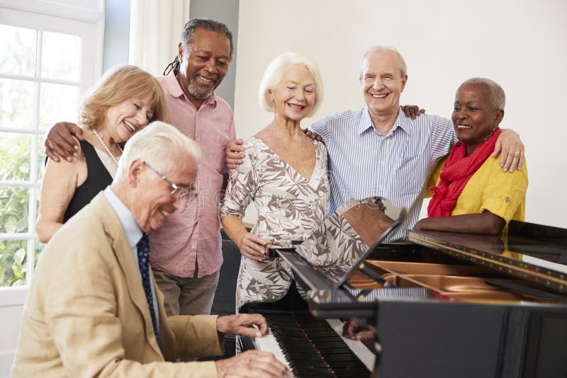 Group Of Seniors Standing By Piano And Singing Together. Group Of Seniors Standing By Piano And Singing Together