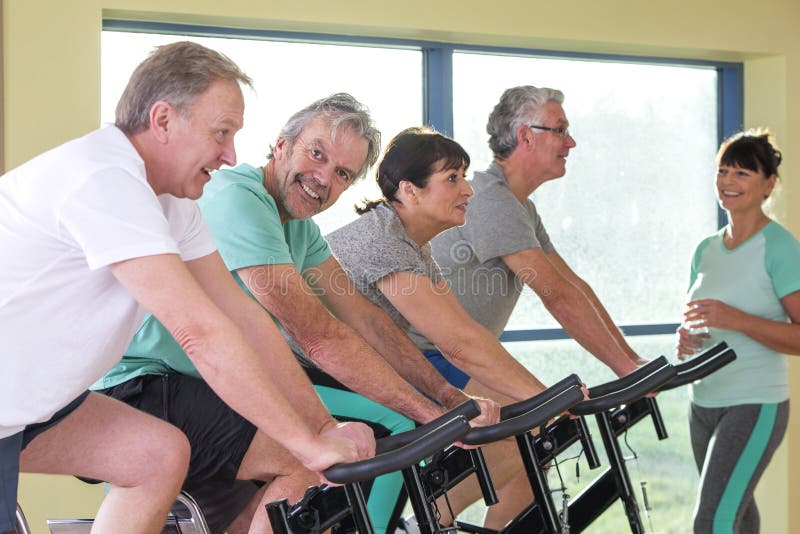 A group of seniors using the spinning bikes at the gym. A group of seniors using the spinning bikes at the gym