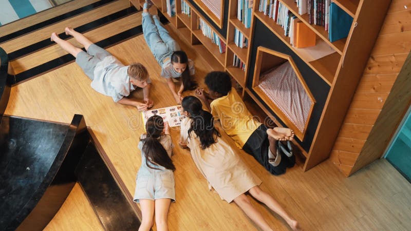 Groupe d'enfants allongés dans un cercle en lisant un livre. édification banque de vidéos