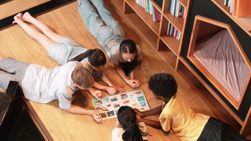 Groupe d'enfants allongés dans un cercle en lisant un livre. édification clips vidéos