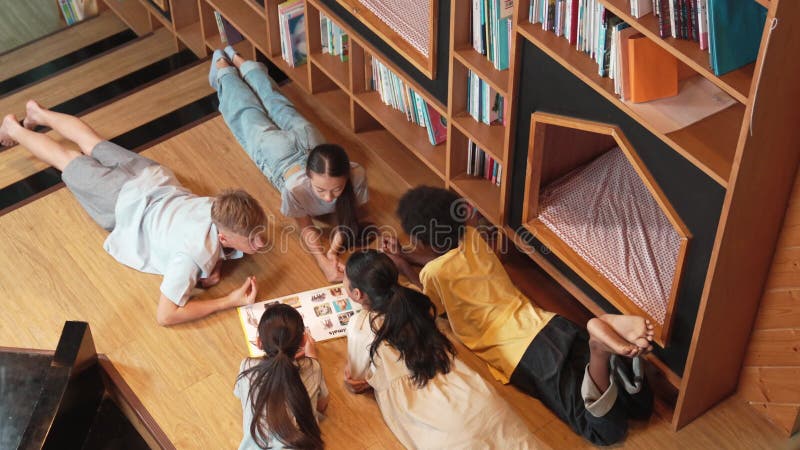 Groupe d'enfants allongés dans un cercle en lisant un livre. édification clips vidéos