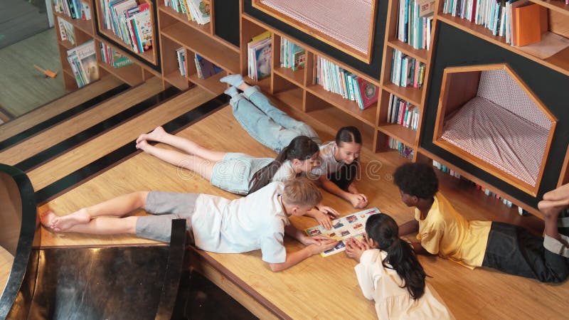 Groupe d'enfants allongés dans un cercle en lisant un livre. édification banque de vidéos
