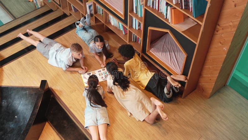 Groupe d'enfants allongés dans un cercle en lisant un livre. édification banque de vidéos