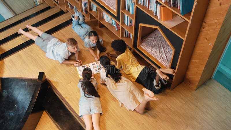 Groupe d'enfants allongés dans un cercle en lisant un livre. édification clips vidéos