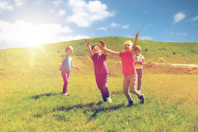 Groupe d'enfants heureux courant dehors photos stock