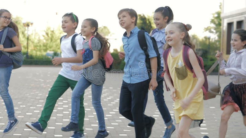 Groupe d'enfants heureux retournant de l'école ensemble banque de vidéos