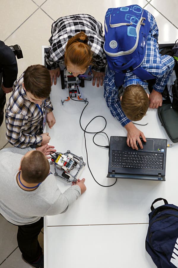 Groupe d'enfants programmant le robot aux concours de robotique image stock Groupe d'enfants programmant le robot aux concours de robotique image stock