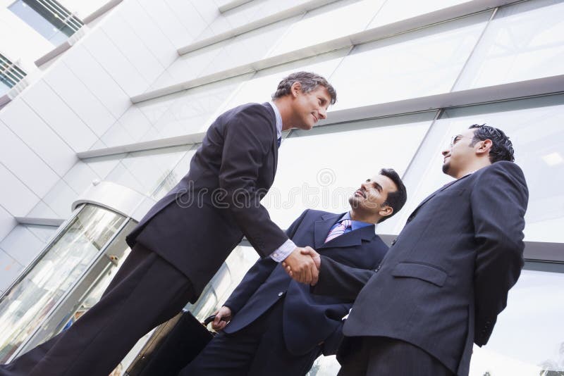 Groupe d'hommes d'affaires se serrant la main en dehors de bureau photo libre de droits Groupe d'hommes d'affaires se serrant la main en dehors de bureau photo libre de droits