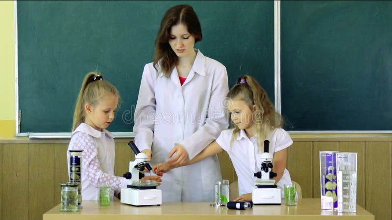 Groupe d'élèves avec la classe À l'aide de Science du professeur In Microscopes Une fois de plus à l'école et à l'enseignement à