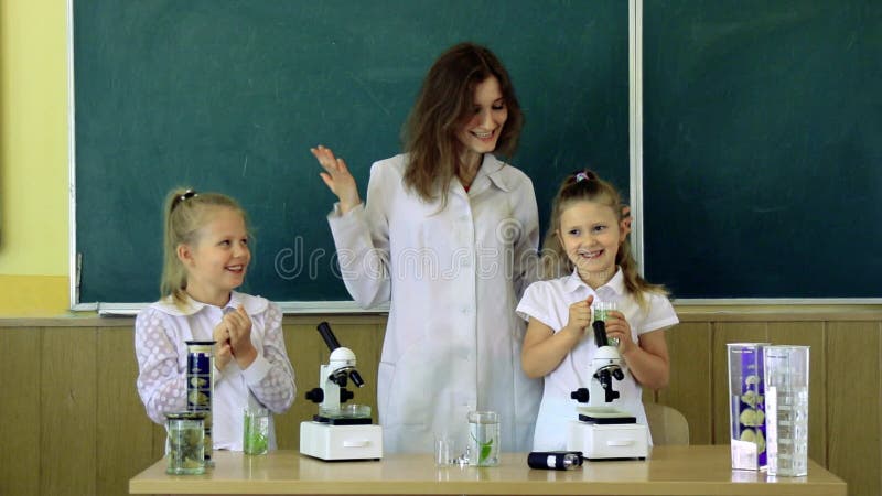 Groupe d'élèves avec la classe À l'aide de Science du professeur In Microscopes Une fois de plus à l'école et à l'enseignement à