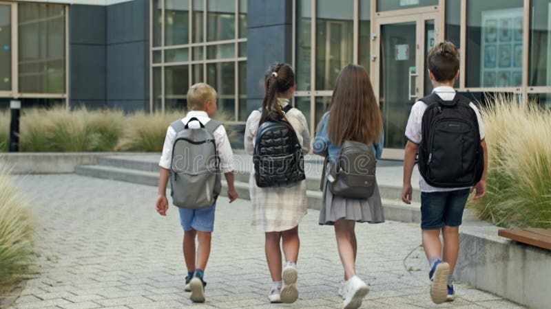 Groupe d'élèves du primaire se précipitent pour donner une leçon à l'école. retour à l'école. banque de vidéos