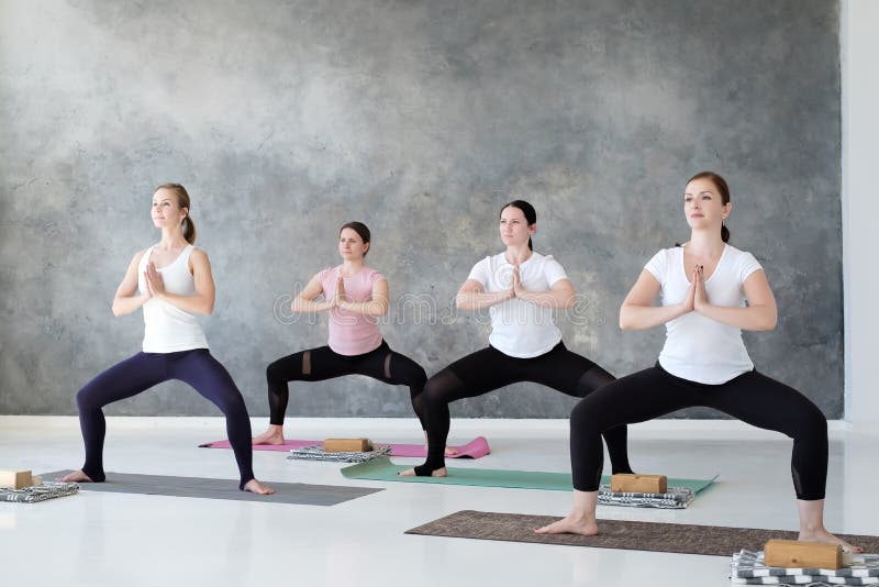 Groupe d'étudiants concentrés de yoga faisant la pose de rudrasana ou de déesse photo libre de droits Groupe d'étudiants concentrés de yoga faisant la pose de rudrasana ou de déesse photo libre de droits
