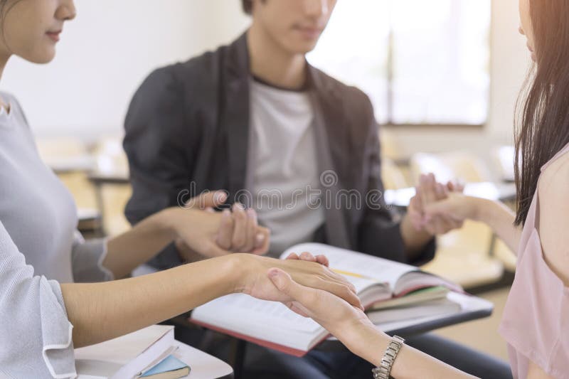 Groupe d'étudiants tenant des mains et priant avant d'apprendre et educ photo libre de droits Groupe d'étudiants tenant des mains et priant avant d'apprendre et educ photo libre de droits