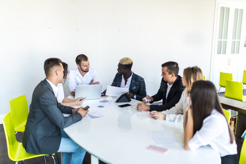 Groupe de cadres commerciaux divers tenant une réunion autour d'une table discutant des graphiques montrant l'analyse statistique photo stock Groupe de cadres commerciaux divers tenant une réunion autour d'une table discutant des graphiques montrant l'analyse statistique photo stock